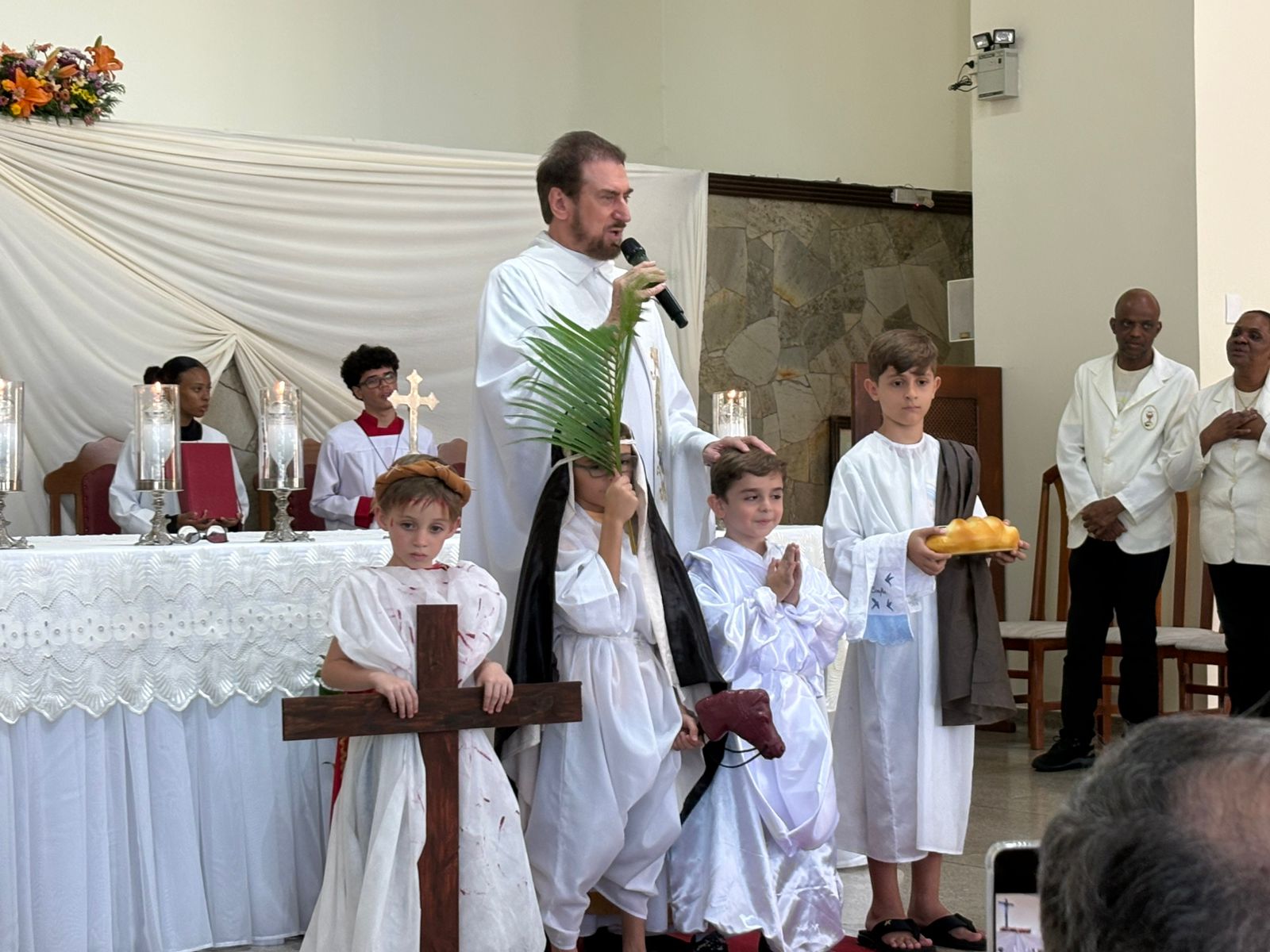 Padre abençoa as crianças caracterizadas durante a celebração
