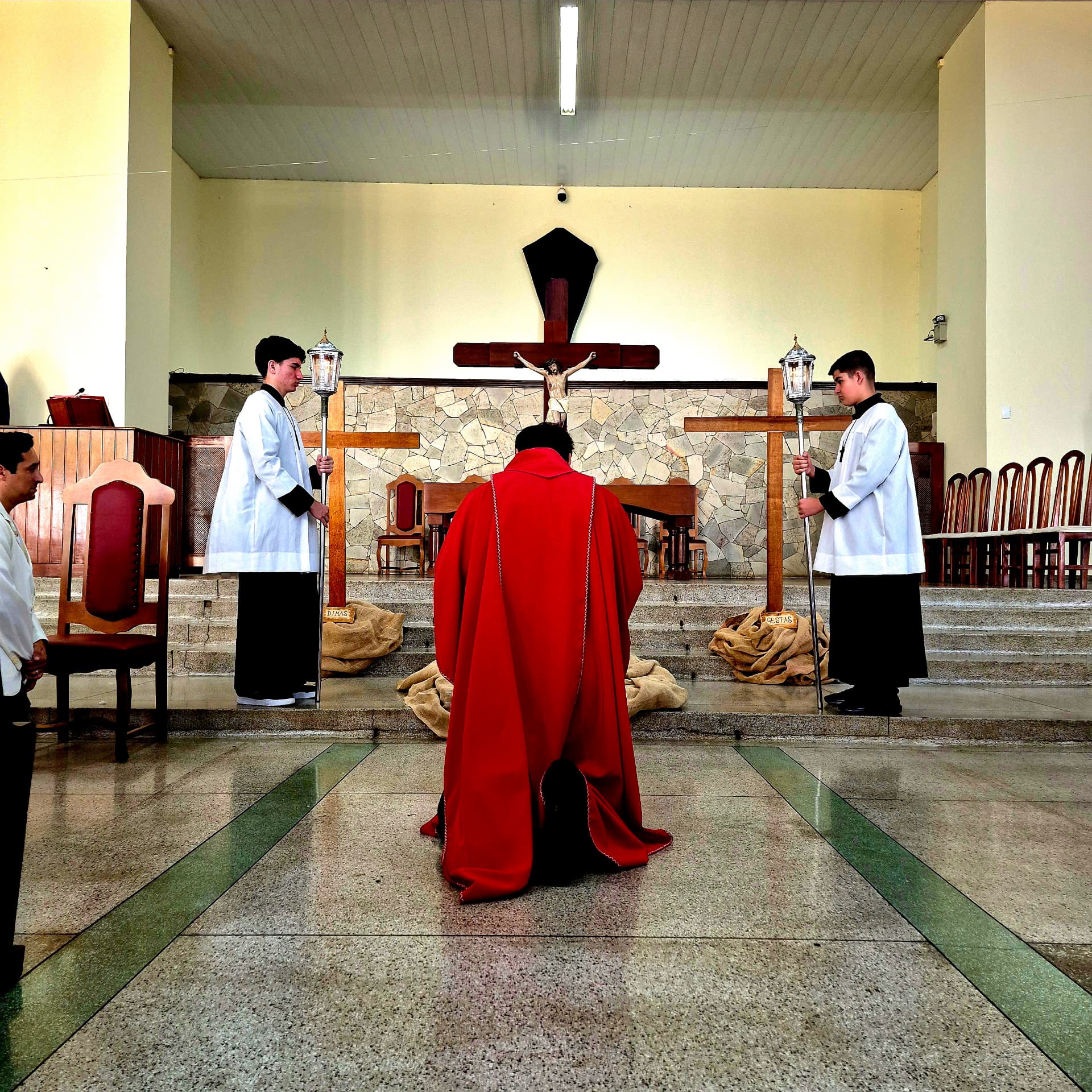 Padre prostrado diante do altar no início da celebração