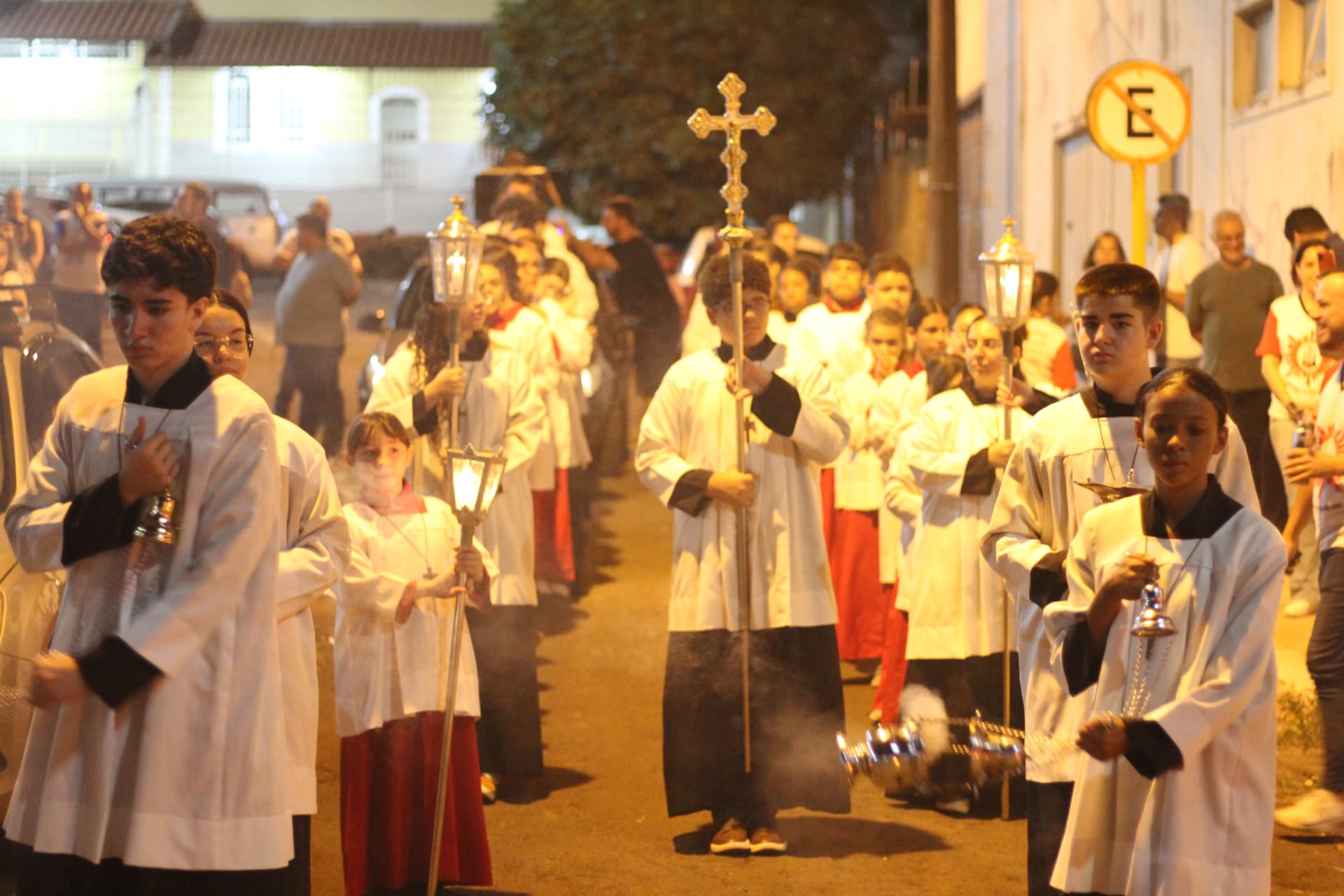 Cortejo com cruz, lanternas e incenso pelas ruas do bairro