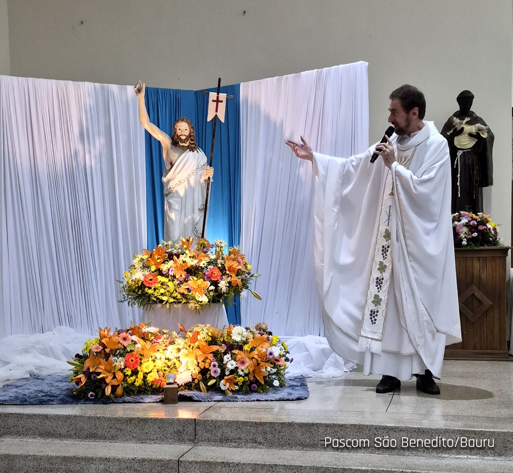 Padre celebrando diante da imagem do Ressuscitado