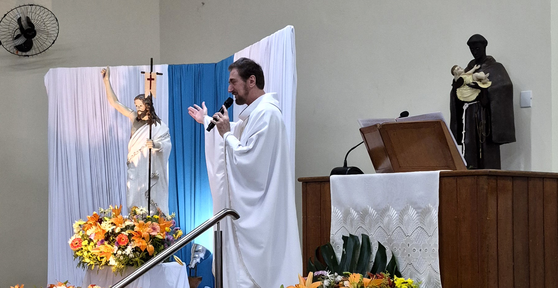 Padre Milton Carraschi pregando ao lado do Cristo Ressuscitado